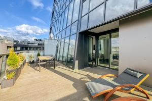 a balcony with a table and chairs on a building at Hanza Tower Apartment no. 701 - Swimming pool, jacuzzi, terrace in Szczecin