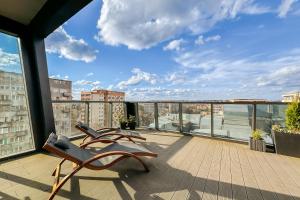 a balcony with chairs and a view of a city at Hanza Tower Apartment no. 701 - Swimming pool, jacuzzi, terrace in Szczecin