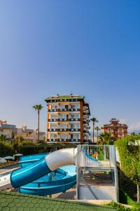 un tobogán acuático en un parque acuático con un edificio en DE MARE FAMILY Hotel, en Konaklı