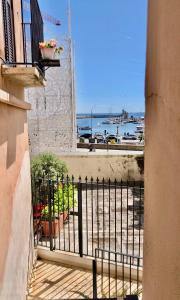 Un balcón de un edificio con vista al agua. en HomeClass Mercantile, en Bari