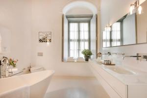 a white bathroom with a sink and a mirror at Hydrea Exclusive Hospitality in Hydra