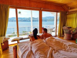 SviniţaDream Tricule的一男一女坐在窗前的床上