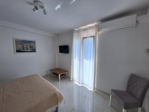 una camera con un letto e una sedia e una finestra di Apartman Graciela Perfect location Gradac a Gradac (Grado)