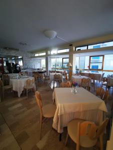 ein Restaurant mit weißen Tischen, Stühlen und Fenstern in der Unterkunft Hotel Prestige 3 Stars in Rimini