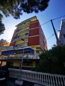 um edifício alto com um vermelho e amarelo em Hotel Prestige 3 Stars em Rimini