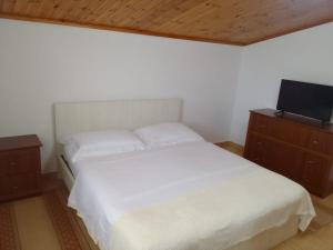 um quarto com uma cama branca e uma televisão de ecrã plano em Akid&Alan Apartment em Tirana