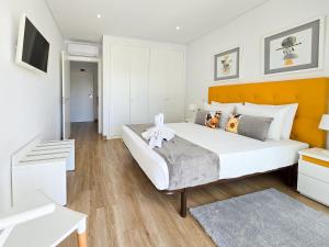 Un dormitorio con una gran cama blanca y un televisor. en Apartment Praia Rocha Residence Honey Glow, en Portimão 23 fotos más