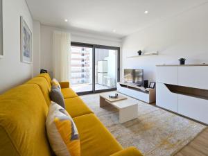sala de estar con sofá amarillo y TV en Apartment Praia Rocha Residence Honey Glow, en Portimão