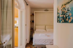 a bedroom with a bed and a painting on the wall at 23Baci, Capri in Capri