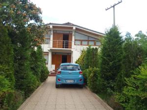 um carro azul estacionado em frente a uma casa em Akid&Alan Apartment em Tirana