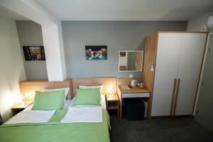 Schlafzimmer mit einem grünen Bett und einem Schreibtisch in der Unterkunft Imperial rooms in Mostar