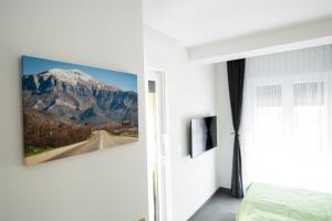 ein Schlafzimmer mit einem Berggemälde an der Wand in der Unterkunft Imperial rooms in Mostar