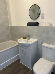 een badkamer met een wastafel, een toilet en een spiegel bij Free Parking! Comfy home in Barwell, Leicester -b- 