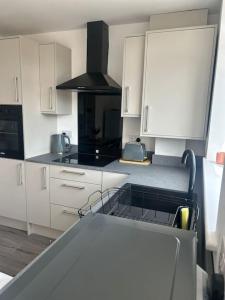 a kitchen with white cabinets and a stove at Free Parking! Comfy home in Barwell, Leicester -b- 