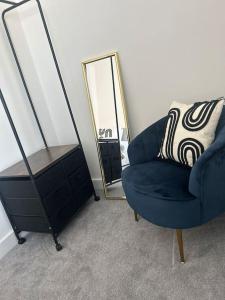 een blauwe stoel en een dressoir met een spiegel bij Free Parking! Comfy home in Barwell, Leicester -b- 
