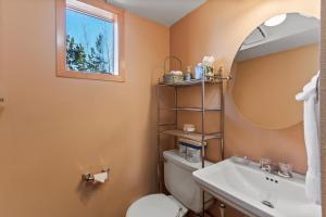 a bathroom with a toilet and a sink and a mirror at Lagoon 723D by Great Western Lodging in Frisco