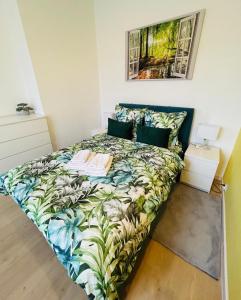 1 dormitorio con 1 cama con colcha tropical en Apartment Targowa L10, en Lublin
