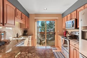 a kitchen with wooden cabinets and a large window at Lagoon 723D by Great Western Lodging in Frisco +19 photos