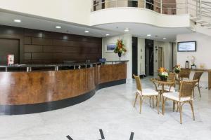 a lobby with a reception desk and a table with chairs at The Palace Flat Moema in Sao Paulo