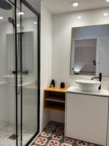 ein Badezimmer mit Dusche, Waschbecken und Spiegel in der Unterkunft Casa da Beira Mar in Aveiro