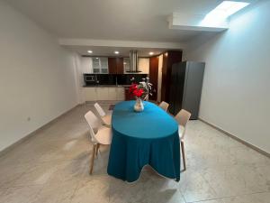 einen blauen Tisch in einem Zimmer mit Stühlen und einer Küche in der Unterkunft Hope House Parede in Parede