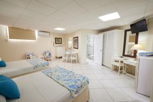 Southern Surf Beach Apartments في بريدج تاون: غرفة مستشفى بسريرين وطاولة