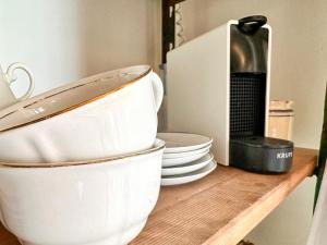 a stack of plates and bowls on a wooden shelf at Residenza dell'Orto - Residenze Tonnina Group in Guardistallo