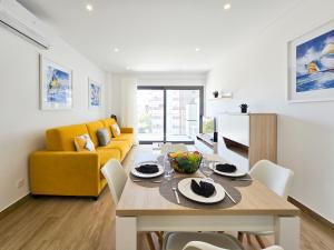 sala de estar con mesa y sofá amarillo en Apartment Praia Rocha Residence Honey Glow, en Portimão