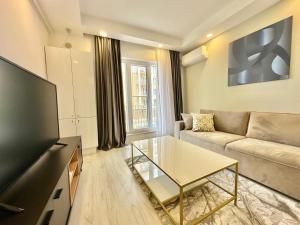 een woonkamer met een bank en een tv bij Double Studio B105 StayInn by Cosmopolis in Creţuleasca +8 foto's