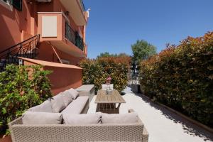 eine Terrasse mit Sofas und einem Tisch auf einem Gebäude in der Unterkunft Corfu Town Luxury Studios -A in Korfu-Stadt