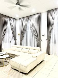 een woonkamer met witte meubels en grote ramen bij Kembara Homestay Four Room in Alor Setar