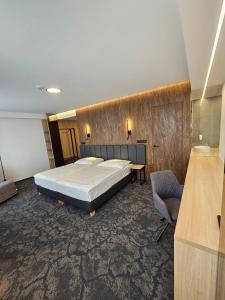 a bedroom with a bed and a desk and a chair at Harmony Club Hotel in Ostrava