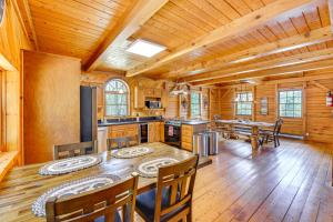 una cocina con mesa y sillas en una cabaña en Exquisite Cabin with Deck and Fire Pit, 10 Mi to Lake, en Athol