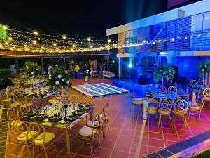 un salón de banquetes con mesas, sillas y luces en Finca El Descanso, en Villavicencio