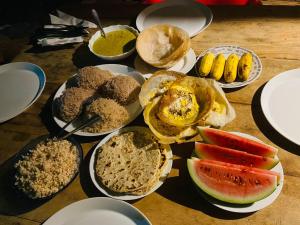 une table recouverte de assiettes de différents types de denrées alimentaires dans l'établissement Yala Village Eco Tree House, à Tissamaharama