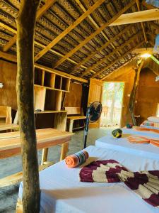 a room with two beds and a table in it at Yala Village Eco Tree House in Tissamaharama