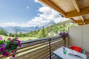 uma varanda com uma mesa e vista para as montanhas em Inntaler Hof em Seefeld no Tirol