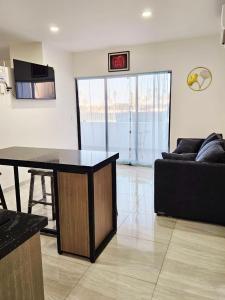 a living room with a black table and a couch at Marina Cerritos Coral del Mar - 4 Albercas de Lujo - 1 Min Playas in Mazatlán