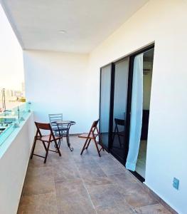 a balcony with chairs and a table in a building at Marina Cerritos Coral del Mar - 4 Albercas de Lujo - 1 Min Playas in Mazatlán