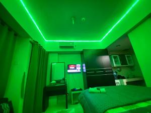 um quarto verde com uma cama e um espelho em APARTEMEN MARGONDA RESIDENCE 3 DEPOK By DBancah Rooms 719 em Kemirimuka Tiga