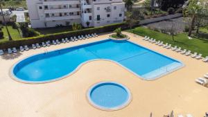 una vista aérea de una piscina con sillas y un edificio en Dunas Hostel & Guesthouse, en Alvor