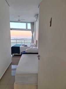 グアルジャにあるSuítes Pitangueirasのベッドルーム1室(ベッド2台付)が備わり、海の景色を望めます。