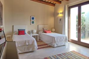 1 dormitorio con 2 camas con sábanas blancas y almohadas rojas en Villa Casale by PosarelliVillas, en Bisciano