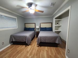 a bedroom with two beds and a ceiling fan at 1976 HoustonGem Luminous Pool & HotTub sleeps11 in Houston