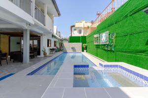 a swimming pool in a building with a green wall at OCEANVIEW HOMESTAY in Alaminos