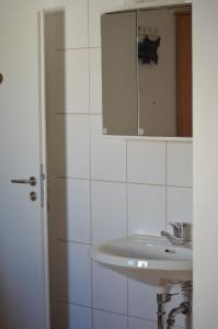 uma casa de banho branca com um lavatório e um espelho em Weingut Sauer-Kettermann em Enkirch