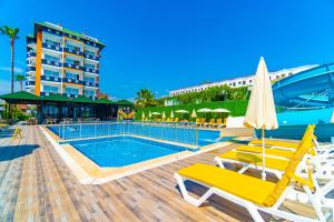 uma piscina com espreguiçadeiras e um hotel em DE MARE FAMILY Hotel em Konaklı