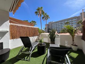 a patio with chairs and plants on a roof at Xookoob Danubio Playa del Ingles in Maspalomas