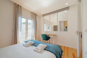 1 dormitorio con cama, escritorio y ventana en Courtyard Oporto Design Apartments by Vacationy, en Oporto