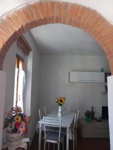 a dining room with a table and a brick archway at Casa Ines - Borgo di Bibbona in Bibbona